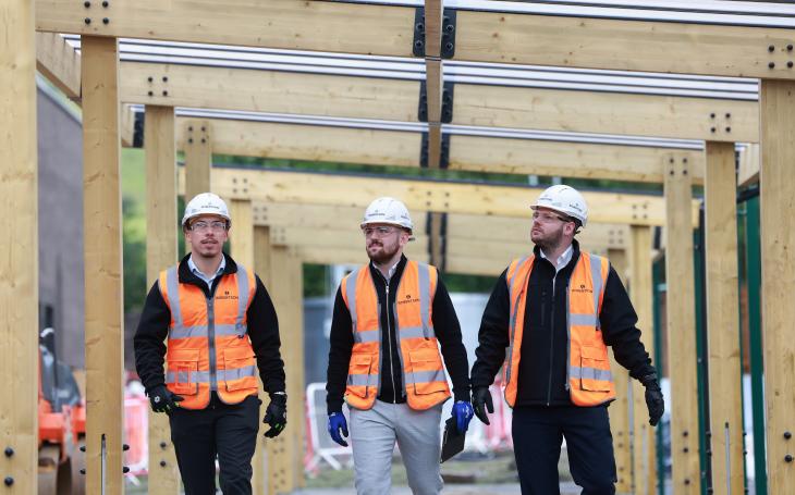 Three members of Robertson's site team walking towards the camera, discussing the project.