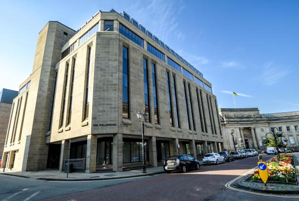 Exterior of a refurbished office building called The Wellsprings, next to Bolton Central Library