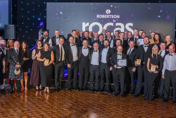 Group of people standing at the Supply Chain Robertson Outstanding Contribution Awards holding their accolades and celebrating