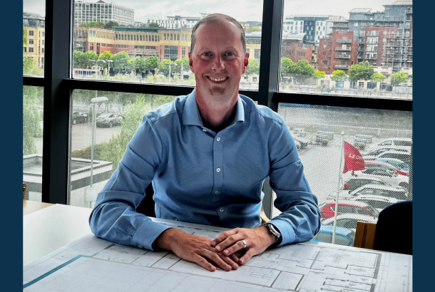 New Managing Director of Robertson Construction North East sat behind construction plans in front of a glass window