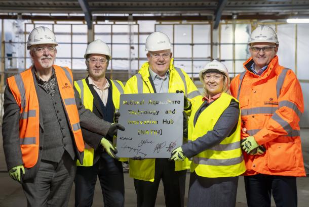 People holding a steel plaque