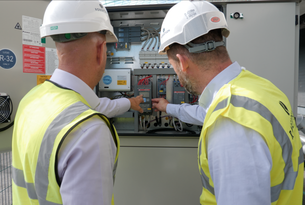 Image of two construction workers checking an electric meter to monitor decarbonisation and energy use