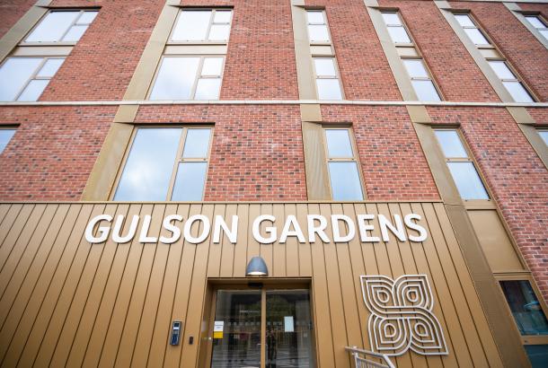 The exterior of the building which displays a large white sign that reads "Gulson Gardens".