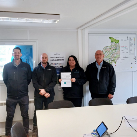 Robertson employees standing with a Considerate Constructors Scheme certificate