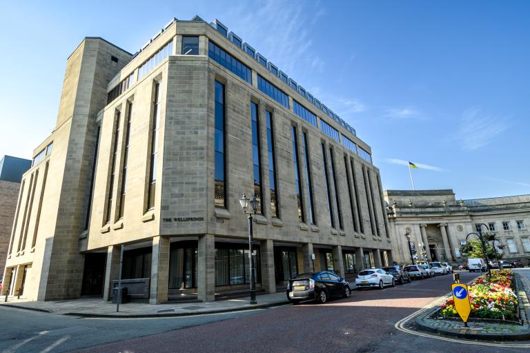 Exterior of a refurbished office building called The Wellsprings, next to Bolton Central Library