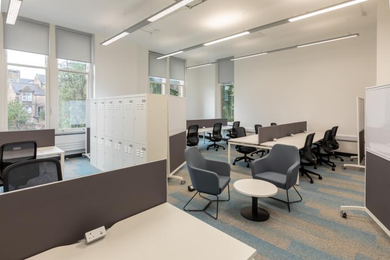 Well-lit university study space with grey carpets and white walls