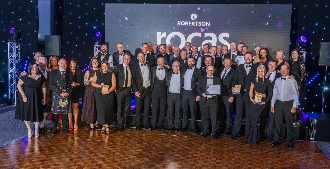 Group of people standing at the Supply Chain Robertson Outstanding Contribution Awards holding their accolades and celebrating