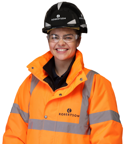 A woman in construction clothing wearing hard hat and protective goggles